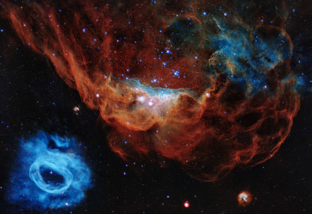 Space image - red nebula and its blue neighbor are part of a star-forming region 163,000 light-years away